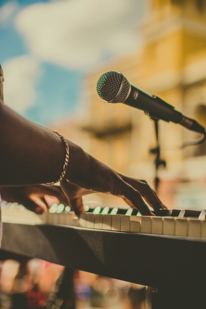 pexels-photo-2927080-2927080 Musician playing piano and singing with a microphone outdoors in San Juan.